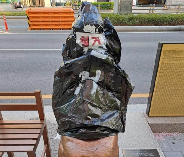 「撤去」と書かれた黒いビニール袋がかぶせられた少女像