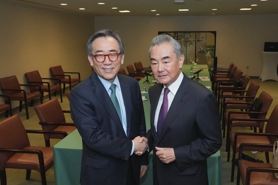 第７９回国連総会に出席中の韓国外交部の趙兌烈長官（左）が２８日に中国の王毅外相との会談に先立ち握手している。［写真　韓国外交部］