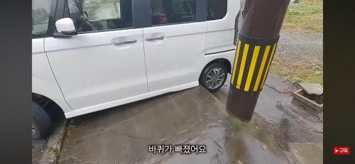 縁石に乗り上げているレンタカー。［ユーチューブ　キャプチャー］