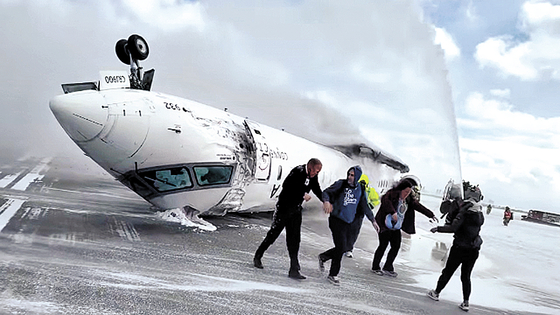 上下逆さまになった旅客機から脱出する乗客たち。［インスタグラム　キャプチャー］
