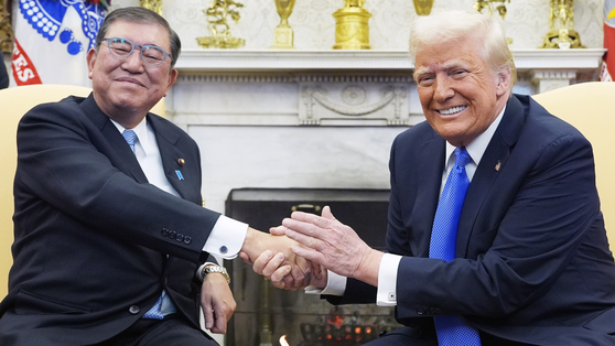 石破首相と握手するトランプ大統領。［写真　ＡＰ＝聯合ニュース］