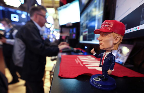 １４日、ニューヨーク証券取引所（ＮＹＳＥ）のトレーダーの机の上にトランプ米大統領の人形が置かれている。［写真　ＡＦＰ＝聯合ニュース］