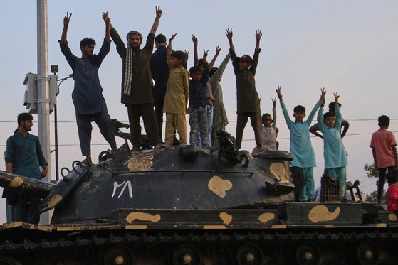 １０日にインドとパキスタンが停戦合意に至ったのを記念してパキスタン市民が戦車の模型の上に上がって歓呼している。［写真　ＡＰ＝聯合ニュース］