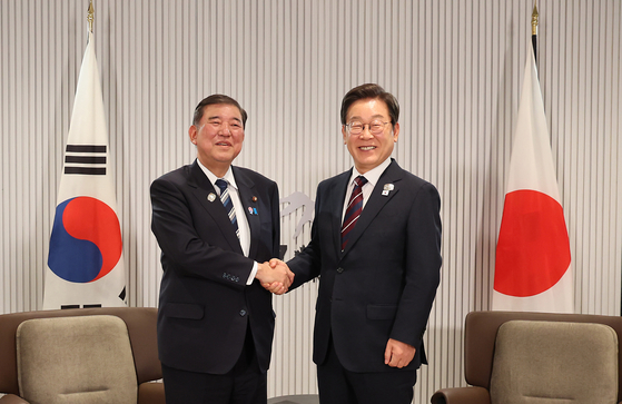 韓国の李在明（イ・ジェミョン）大統領が１７日（現地時間）、カナダ・アルバータ州カナナキスの主要７カ国首脳会議（Ｇ７サミット）の会場で開かれた韓日首脳会談で、石破茂首相と握手して記念撮影をしている。［写真　聯合ニュース］