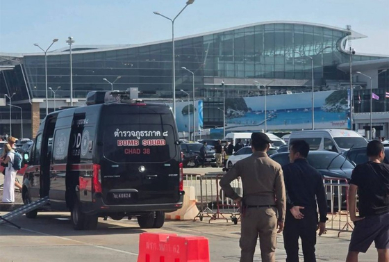 タイ南部プーケット国際空港旅客ターミナル近くで２５日、警察が爆発物を載せたバイクを発見し除去する様子。［バンコクポスト　キャプチャー］