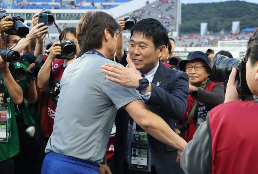試合の前にあいさつを交わす洪明甫（ホン・ミョンボ）監督と森保一監督　［聯合ニュース］
