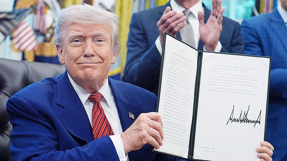 トランプ米大統領が５月にホワイトハウスで自身が署名した大統領令の書類を持ち上げて見せている。［写真　ＡＰ＝聯合ニュース］
