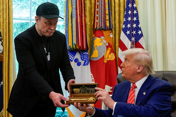トランプ大統領がマスク氏にお別れの贈り物を渡している。［写真　ロイター＝聯合ニュース］