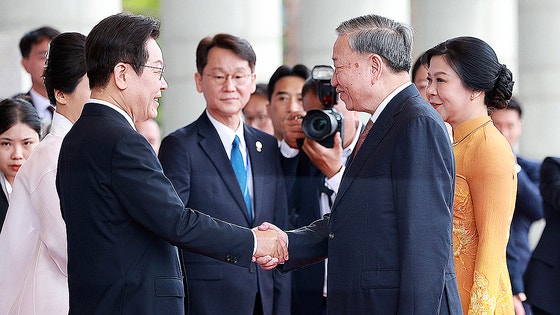 李在明（イ・ジェミョン）大統領が１１日、ソウル竜山大統領室庁舎で国賓訪問したベトナムのトー・ラム共産党書記長夫妻を迎えて握手している。　［聯合ニュース］