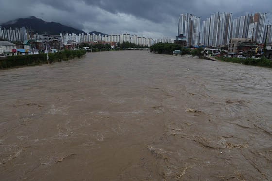 首都圏に集中豪雨が降った１３日、京畿道議政府市（キョンギド・ウィジョンブシ）の中浪川（チュンランチョン）で水が増している。［写真　聯合ニュース］