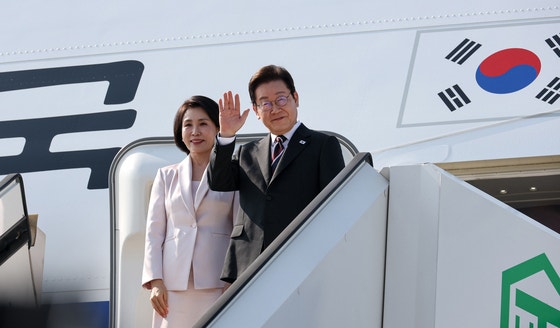 李在明大統領と金恵景夫人が２日間の訪日日程を終え２４日午後に羽田空港から米ワシントンに向かう専用機に搭乗しながらあいさつしている。［写真　大統領室写真記者団］