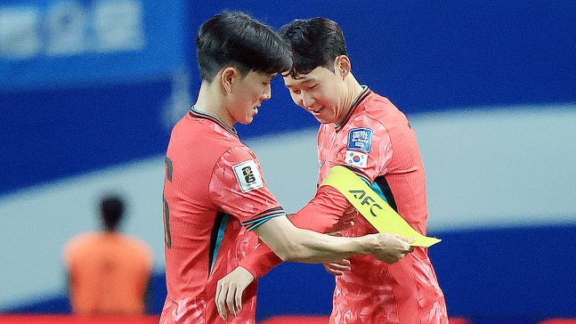 ６月１０日、ソウルＷ杯競技場で開催された北中米Ｗ杯アジア３次予選のクウェート戦で、韓国代表の黄仁範（ファン・インボム、左）が後半戦に交代出場した孫興慜（ソン・フンミン）に主将の腕章を渡している。　［ニュース１］