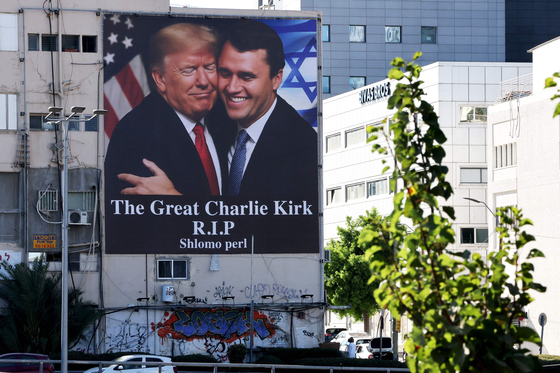 13日（現地時間）、イスラエル・テルアビブのある建物に、ドナルド・トランプ米国大統領（左）と10日の銃撃で死亡した保守右翼活動家チャーリー・カーク氏が一緒に写った大型写真が壁面に掲げられている。写真には「偉大なるチャーリー・カーク、安らかに眠れ」という言葉が添えられている。［写真 AFP＝聯合ニュース］