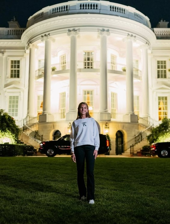   ホワイトハウスを背景に、自身のアパレルブランドを宣伝するトランプ米大統領の孫娘。［SNS キャプチャー］