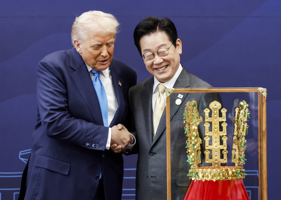 韓国の李在明（イ・ジェミョン）大統領が29日、慶州（キョンジュ）博物館でトランプ米大統領に「天馬塚金冠模型」を贈った後、握手している。 チョン・ミンギュ記者