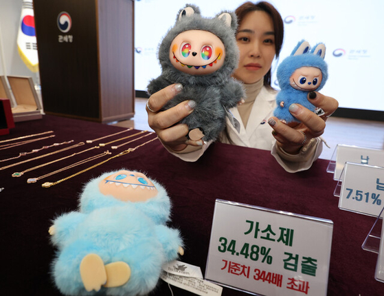 5日、ソウル江南区（カンナムグ）のソウル税関で開かれた「偽造アクセサリーやラブブのキーホルダーなどに関する安全性検査結果のブリーフィング」で、関税庁の関係者が、可塑剤が検出された偽物のラブブ人形を手にして見せている。［聯合ニュース］