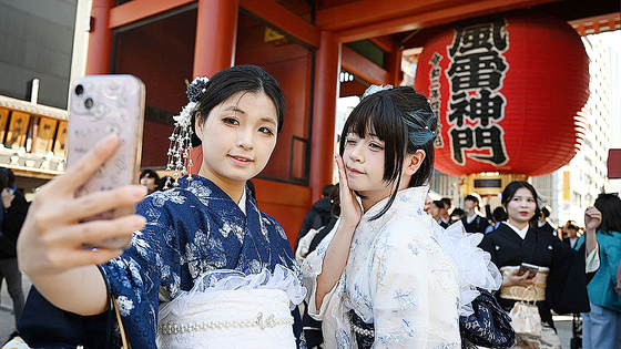 11月15日、東京浅草にある浅草寺を訪れた2人の中国人観光客が、着物を着て記念写真を撮っている。［AFP＝聯合ニュース］