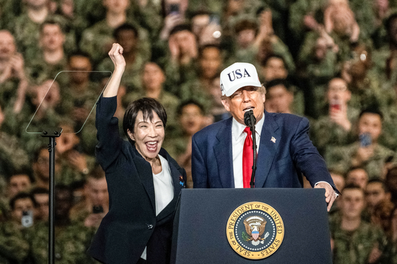 先月28日、横須賀米海軍基地に停泊する空母「ジョージ・ワシントン」でトランプ米大統領の紹介を受けた高市早苗首相が手をあげている。 ［AFP＝聯合ニュース］