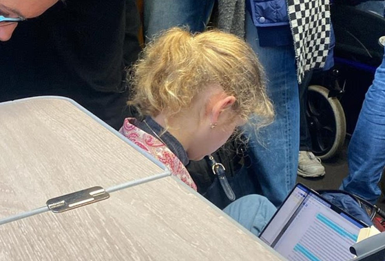   ルイーズ・ウィンザー王女が列車の客室の床に座り、エッセーを書いている。［デイリー・メール　キャプチャー］