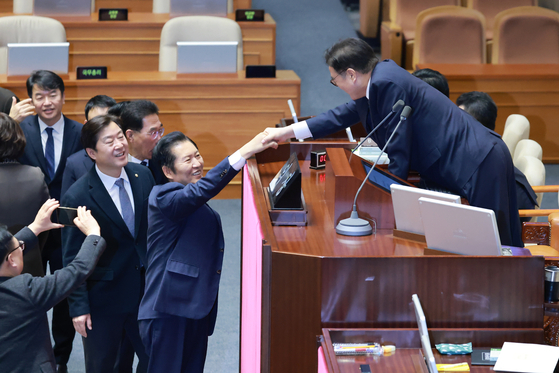 韓国与党「共に民主党」の鄭清来（チョン・チョンレ）代表が昨年12月24日、国会で開かれた12月臨時国会本会議で、前日に上程された情報通信網法改正案に対する無制限討論（フィリバスター）を終結させるための採決を終えた後、禹元植（ウ・ウォンシク）国会議長と握手している。聯合ニュース