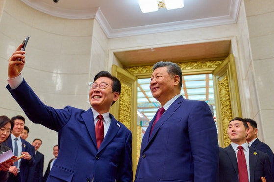 韓国の李在明大統領と中国の習近平国家主席が5日、北京の人民大会堂で夕食会後にシャオミのスマホで自撮りをしている。［写真 青瓦台写真記者団］