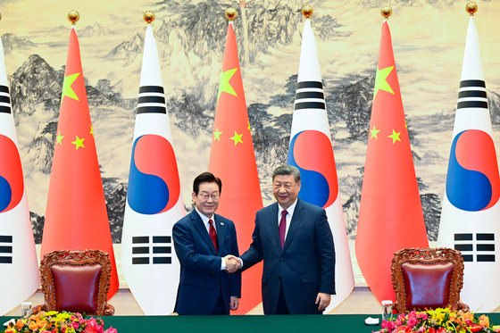   MOU署名式で握手を交わす李大統領と習主席。［写真 青瓦台写真記者団］