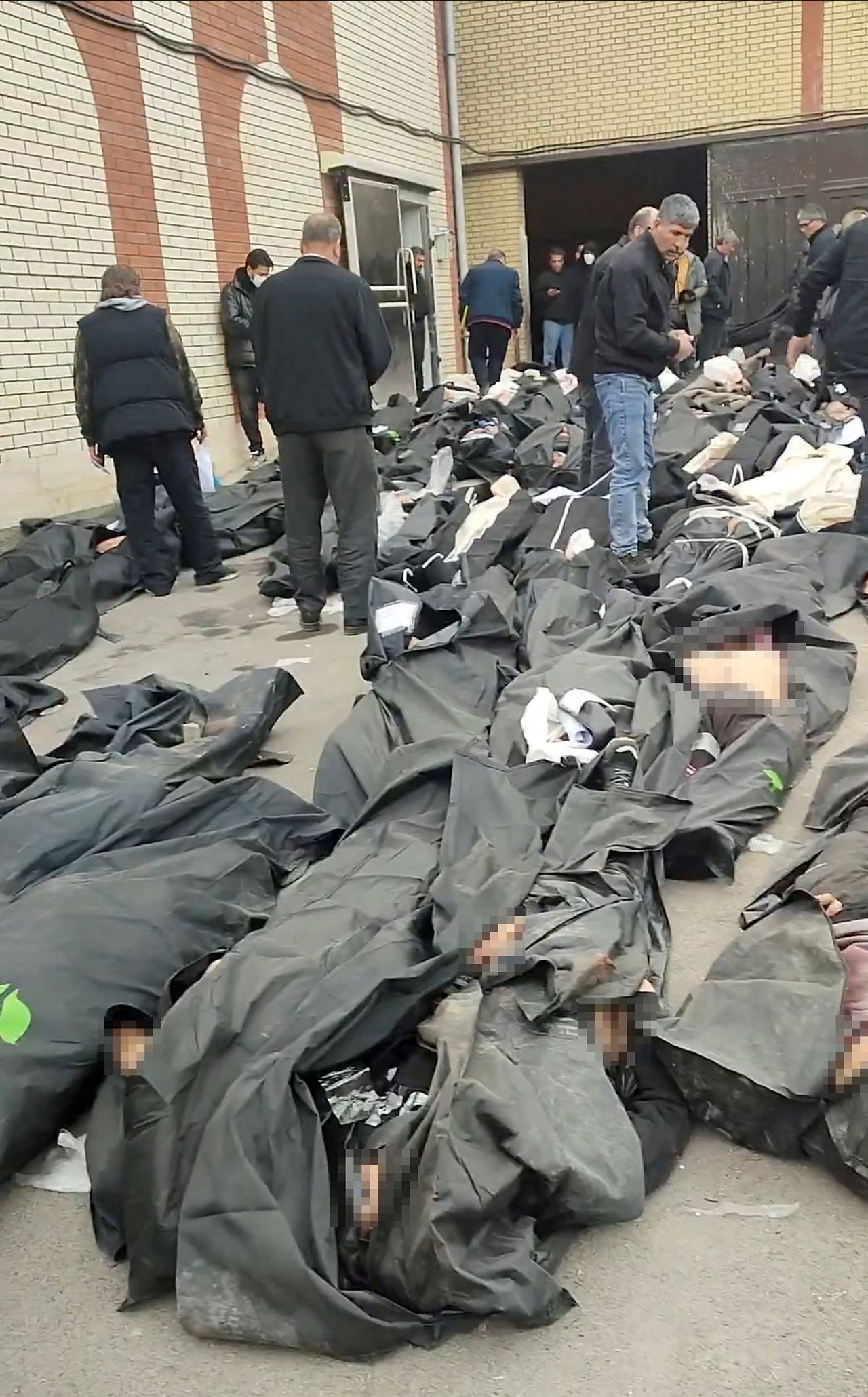   イラン・テヘランの法医学センター付近で反政府デモ中に死亡した人の遺体が並べられている。 ［ロイター＝聯合ニュース］
