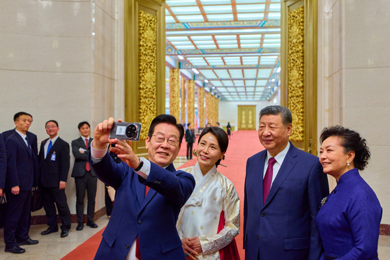  習近平主席夫妻とシャオミフォンで自撮りをする李在明大統領夫妻。聯合ニュース