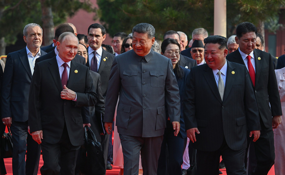 中国の習近平国家主席（中央）が昨年9月3日、中国の戦勝節行事において、北朝鮮の金正恩（キム・ジョンウン）国務委員長およびロシアのウラジーミル・プーチン大統領と会話を交わしながら天安門の城楼へと向かっている。聯合ニュース