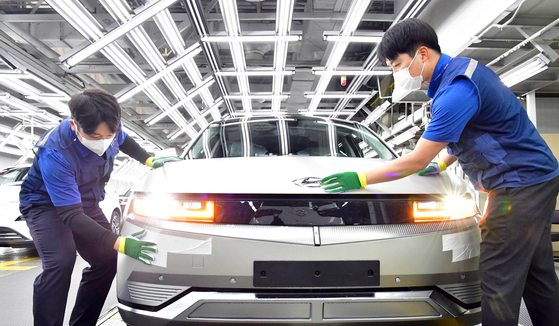 現代自動車蔚山工場の電気自動車「アイオニック5」生産ラインで現場労働者が車を点検している。［写真 現代自動車］