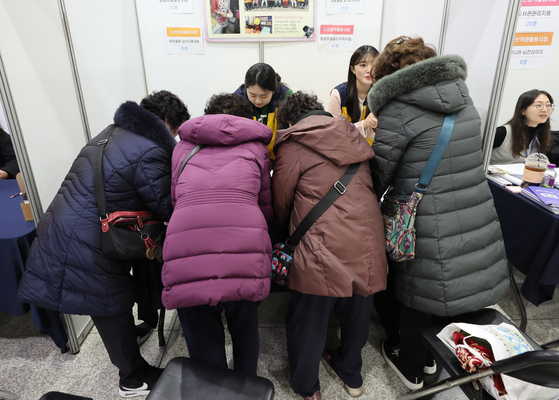 昨年12月10日、ソウル・麻浦区庁で開かれた高齢者雇用博覧会を訪れた市民が雇用申請に向け相談している。［写真 聯合ニュース］