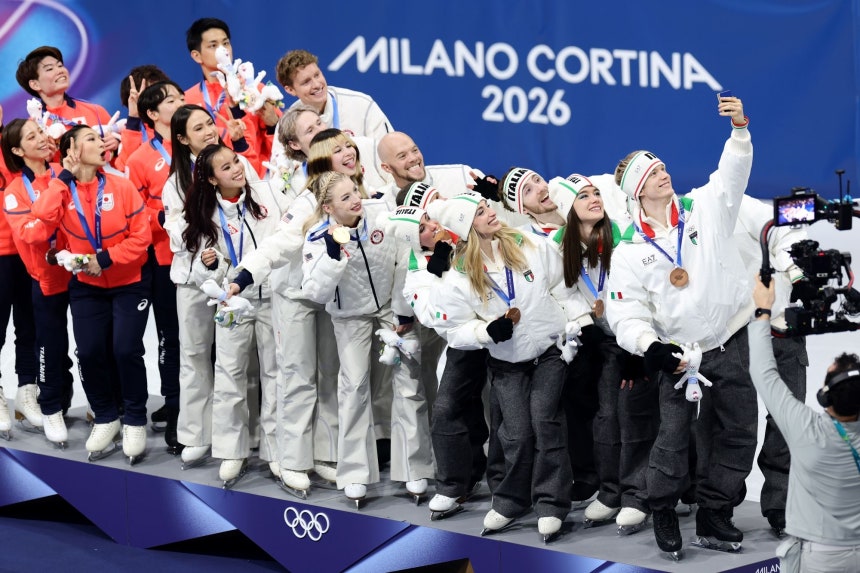 ミラノ・コルティナ冬季五輪フィギュアスケート団体戦で銀メダルの日本チーム、金メダルの米国チーム、銅メダルのイタリアチームの選手らがギャラクシーZフリップ7オリンピックエディションでビクトリーセルフィーを撮っている。［写真 ゲッティイメージ／サムスン電子］