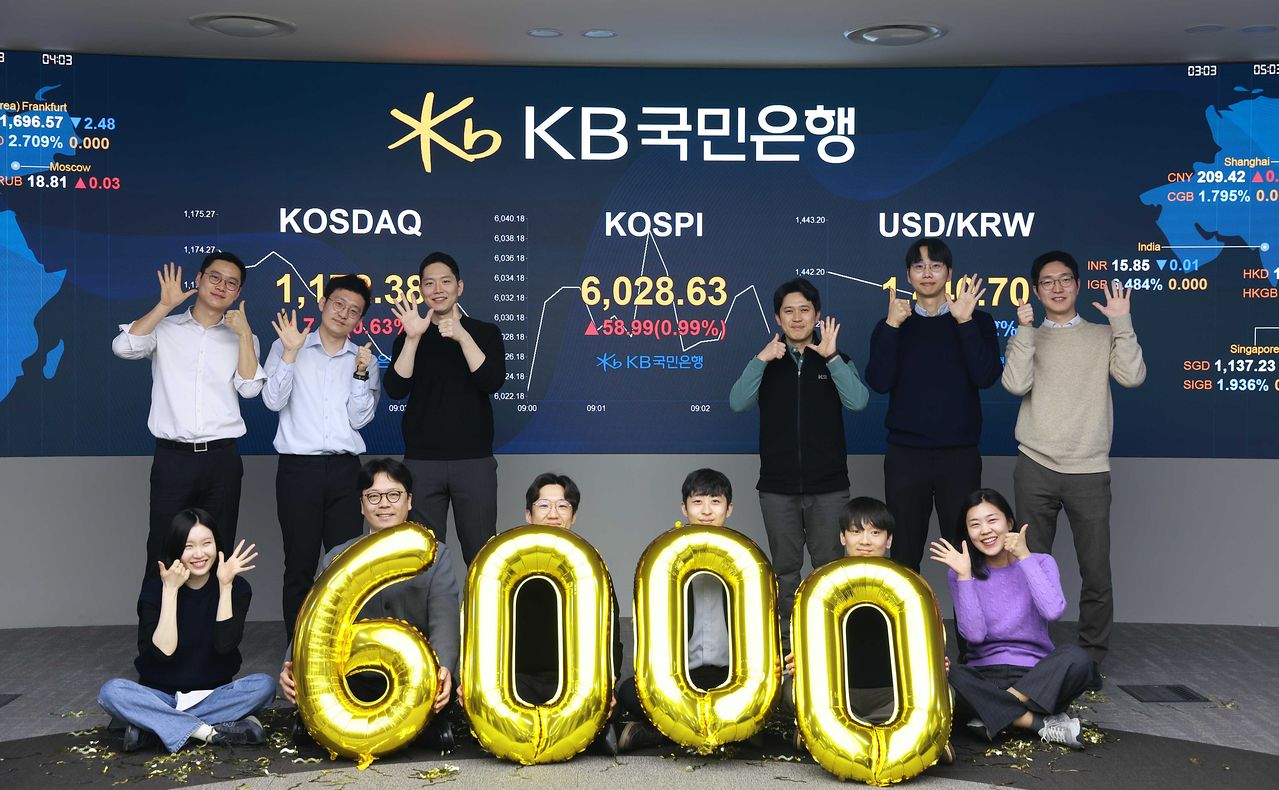 KOSPIが取引開始ととともに6000ポイントを突破した25日、ソウルのKB国民銀行ディーリングルームで従業員が祝賀セレモニーをしている。［写真 国民銀行］
