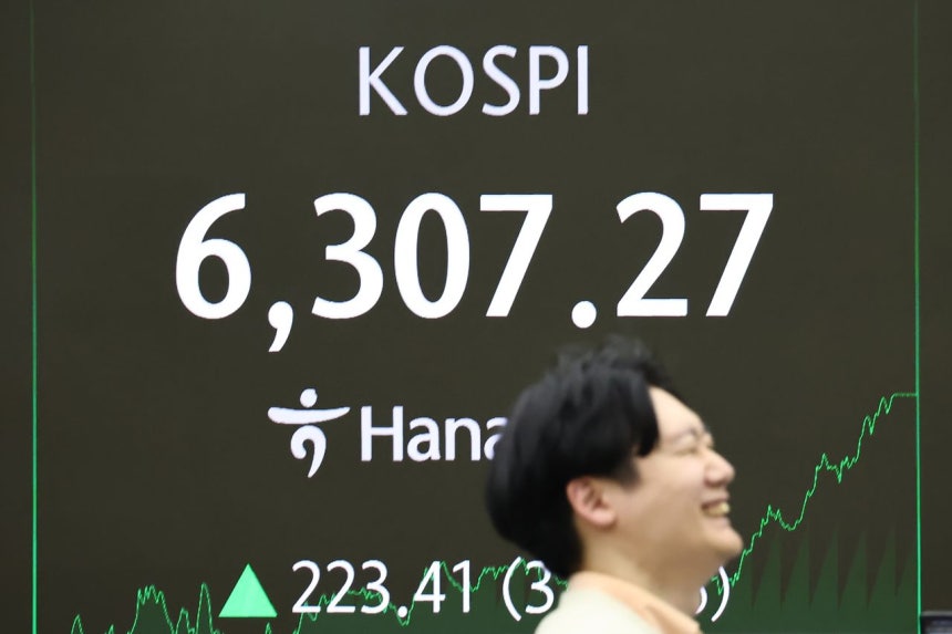 KOSPIが6307．27を記録した26日、ソウルのハナ銀行本店ディーリングルームでディーラーが業務を行っている。［写真 聯合ニュース］
