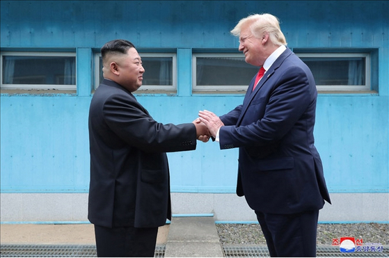 2019年6月30日、板門店（パンムンジョム）で北朝鮮の金正恩（キム・ジョンウン）国務委員長と米国のドナルド・トランプ大統領が対面したと、北朝鮮の朝鮮中央通信が翌日報じた。写真は当時、朝鮮中央通信がホームページで公開したもので、軍事境界線（MDL）を挟んで朝米首脳が握手を交わす様子。聯合ニュース 