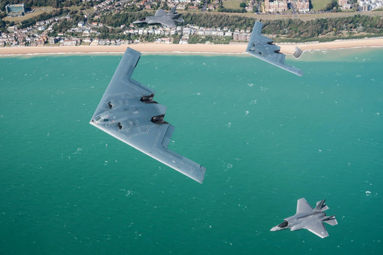 米空軍の戦略爆撃機B2スピリットが英空軍のF35BライトニングⅡの援護を受け飛んでいる。［写真 英国防省］