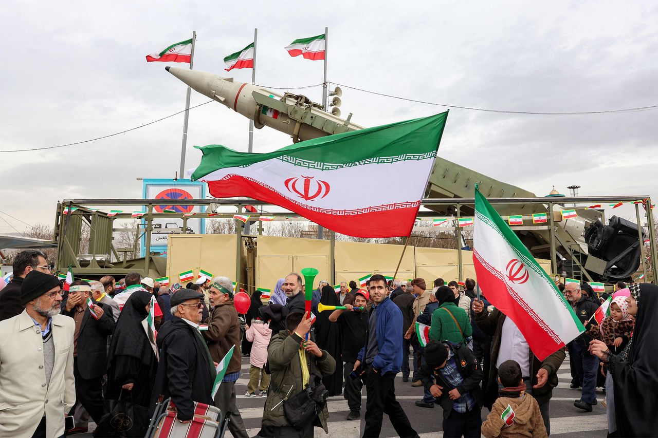 先月11日、イラン・テヘランで開かれたイスラム革命47周年行事で、イラン市民が国旗を手に弾道ミサイル発射台を見物している。［AFP＝聯合ニュース］