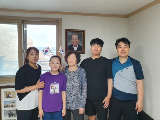 独島（トクド、日本名・竹島）の唯一の住民だったキム・シンヨルさん（中央）が、慶尚北道鬱陵郡鬱陵邑独島里（キョンサンブクド・ウルルングン・ウルルンウプ・トクドリ）の西島（ソド）にある住民宿舎で、娘、娘婿、外孫、孫娘と一緒に記念写真を撮影している。キムさんの後ろには、前年に亡くなった夫のキム・ソンドさんの遺影が掲げられている。聯合ニュース