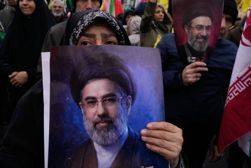 13日（現地時間）、イランのテヘランで開かれた集会で、新しい最高指導者モジタバ・ハメネイ師の支持者がポスターを持っている。［AP＝聯合ニュース］