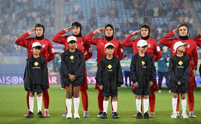 フィリピン戦を前にイラン国歌が演奏される際、挙手敬礼するイラン女子代表選手たち。［ロイター＝聯合ニュース］