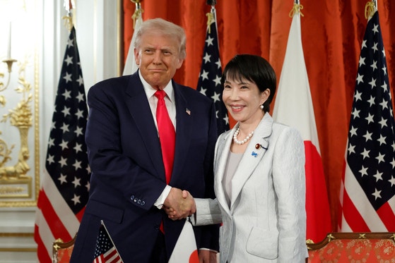 昨年10月28日、東京・赤坂離宮で開かれた米日貿易協定履行文書の署名式で、ドナルド・トランプ米国大統領（左）と高市早苗首相が握手し記念撮影を行っている。ロイター＝聯合ニュース