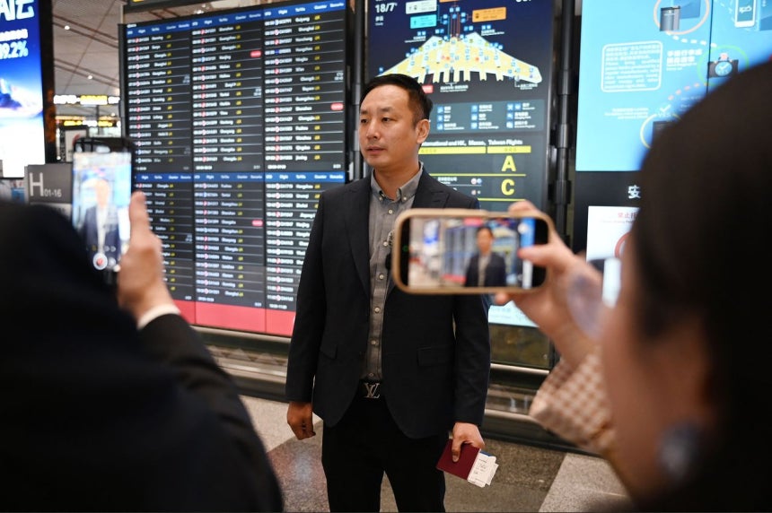 30日、北京・首都空港で出張のため平壌（ピョンヤン）行きエアチャイナ便に搭乗した乗客が、チェックイン後にメディアのインタビューに応じている。［AFP＝聯合ニュース］