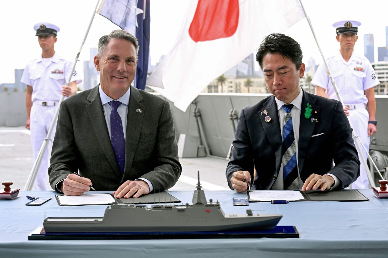 オーストラリアのマールズ副首相兼国防相（左）と日本の小泉進次郎防衛相が18日にメルボルンで日本が「もがみ型」護衛艦のうち最初の3隻を引き渡す契約に署名している。［写真 AFP＝聯合ニュース］
