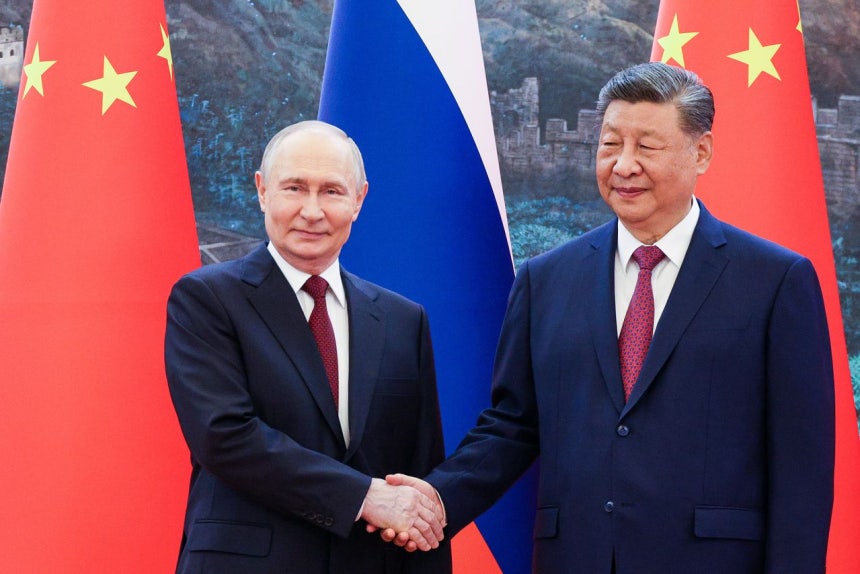 20日、ウラジーミル・プーチン露大統領（左）と習近平中国国家主席（右）が人民大会堂で握手している。習主席は会談で「歴史的機会」を強調した。タス通信