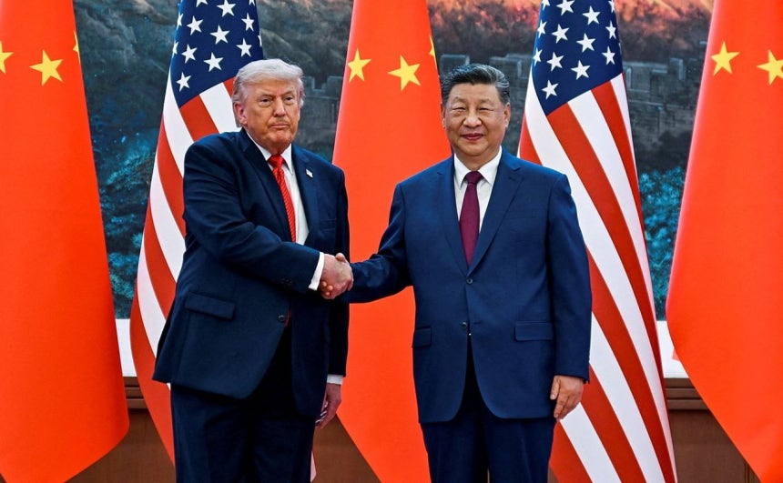 9年ぶりに訪中したトランプ米大統領（左）が14日、中国北京人民大会堂で習近平国家主席と握手している。［ロイター＝聯合ニュース］