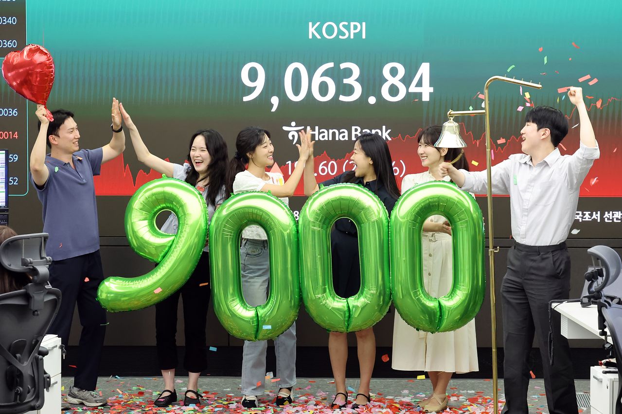 18日午後、KOSPI（韓国総合株価指数）が史上初めて9000の大台を突破して取引を終えたことを受け、ソウル市中区（チュング）のハナ銀行ディーリングルームで職員らが祝賀セレモニーを行っている。キム・ギョンロク記者。