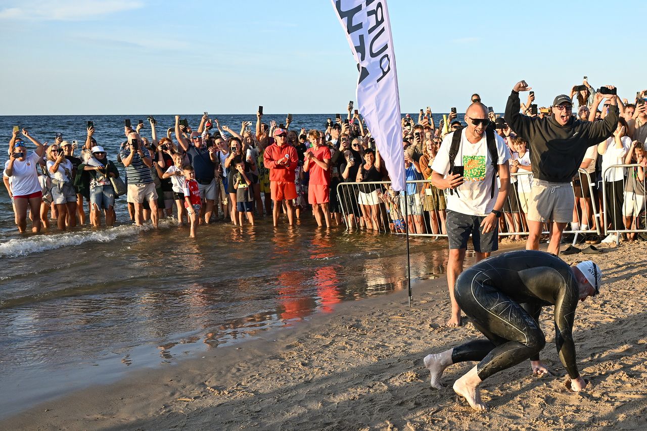  バルト海横断に成功した直後、砂浜に倒れ込むポーランド人水泳選手バルトウォミェイ・クプコフスキ。［EPA＝聯合ニュース］