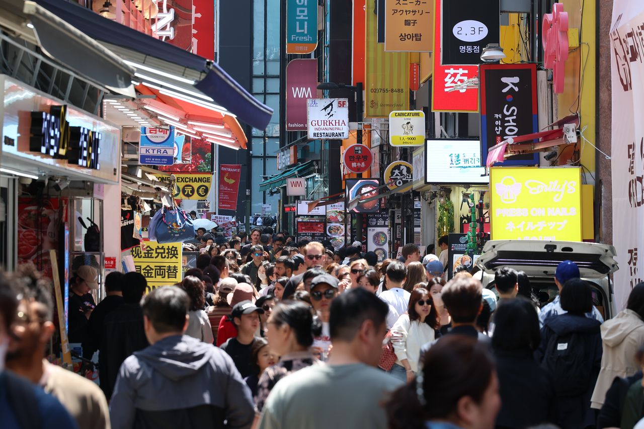 今年5月、ソウル・中区（チュング）の明洞（ミョンドン）を訪れた外国人観光客らが街を見て回っている。［聯合ニュース］