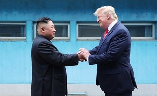 金正恩委員長（左）とトランプ大統領が2019年6月30日に板門店で会い手を取り合っている。［写真 朝鮮中央通信］