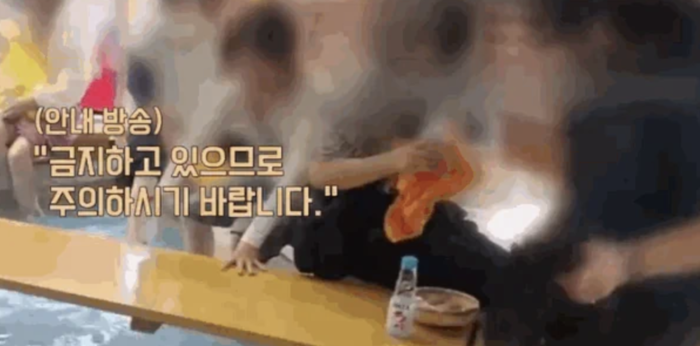 日本の有名温泉の足湯で飲食する韓国人観光客。この温泉では衛生上の理由から足湯での飲食を禁止している。［ユーチューブ キャプチャー］